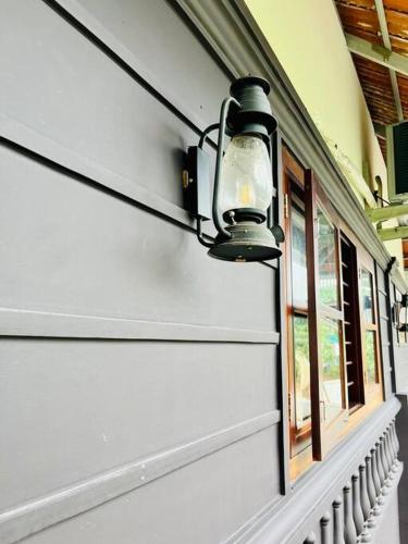 a light on the side of a building with windows at Haven Stay Manor in Kotamangalam