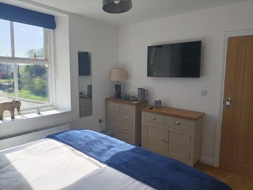 a bedroom with a bed and a tv on the wall at The Tiger Inn in Easington