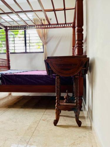 a bed in a room with a wooden frame at Haven Stay Manor in Kotamangalam