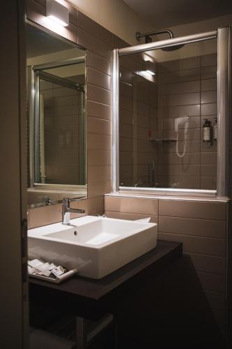 a bathroom with a white sink and a mirror at Lake Hotel La Pieve in Pisogne