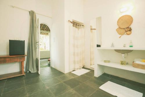 a bathroom with a tiled floor and a sink at Villa Ostello in Paripueira