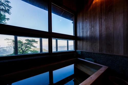 a room with two windows and a pool of water at Suite Villa Ocean View Atami Shizenrou - Japanese style in Atami