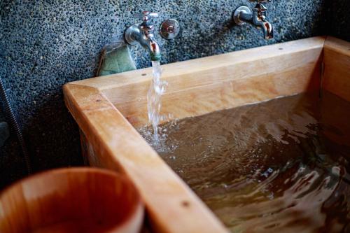 a wooden sink with water coming out of it at Suite Villa Ocean View Atami Shizenrou - Japanese style in Atami