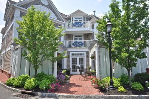 a white house with a blue sign on it at Inn on Main Hotel in Manasquan