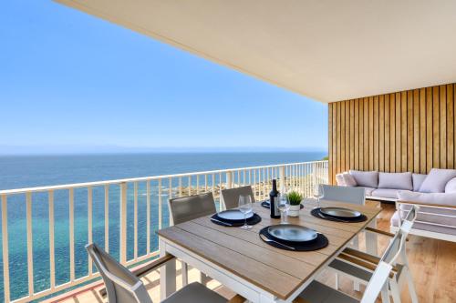a dining table and chairs on a balcony with the ocean at Ático Crucero Suite VIP in Roses