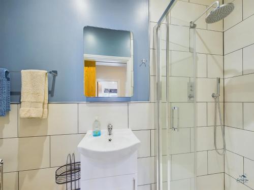 ein Badezimmer mit Waschbecken und Dusche in der Unterkunft Seaside Cottage, Moments from Ryde's Golden Sands, Sleeps 4 in Ryde