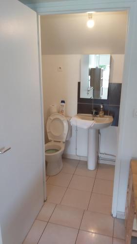 a bathroom with a toilet and a sink at Appartement confortable et fonctionnel - Rickhoss Home in Étampes