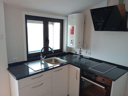 a kitchen with a sink and a counter top at Casa dos Avós Veras in Aveiro