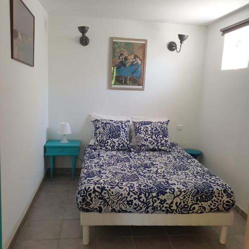 une chambre avec un lit avec une couette bleue et blanche dans l'établissement L'Oliveraie, à Hyères