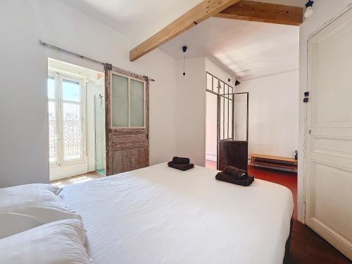 - une chambre dotée d'un grand lit blanc avec deux sacs dans l'établissement Loft au cœur de Marseille - Spacieux & Unique - Les Frères de la Loc', à Marseille