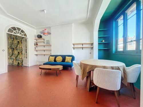 un salon avec une table et un canapé bleu dans l'établissement Loft au cœur de Marseille - Spacieux & Unique - Les Frères de la Loc', à Marseille