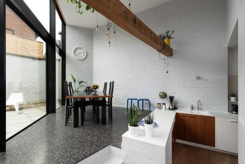 a kitchen with a table and a dining room at Townhouse Tongeren Center - Featured in Designbook in Tongeren