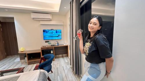 a woman leaning against a wall in a room at Raksha Suites & Banquet Greater Noida in Greater Noida
