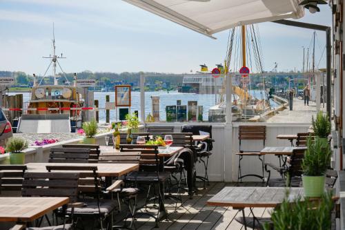 a restaurant with tables and chairs on a patio at Hotel Ærø in Svendborg