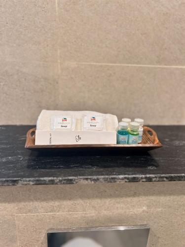 a tray with towels and bottles on a counter at Raksha Suites & Banquet Greater Noida in Greater Noida