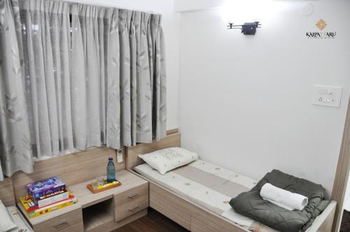 a small room with a bed and a window at Kalpattaru Sadan Luxurios 3BHK in Pune