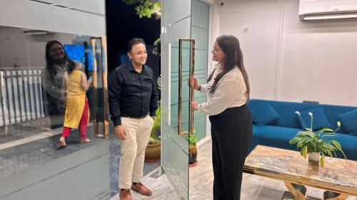 a man and a woman standing in front of a mirror at Raksha Suites & Banquet Greater Noida in Greater Noida