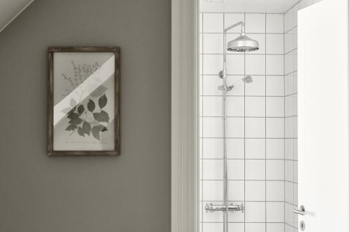 a bathroom with a shower and a picture on the wall at Hotel Ærø in Svendborg