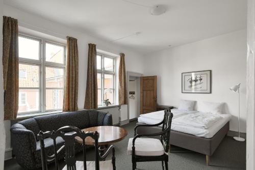 a hotel room with a bed and a table and chairs at Hotel Ærø in Svendborg