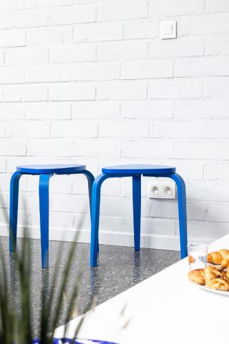 two blue stools in front of a white wall at Townhouse Tongeren Center - Featured in Designbook in Tongeren