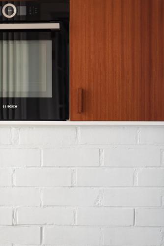 a kitchen with a microwave and a brick wall at Townhouse Tongeren Center - Featured in Designbook in Tongeren