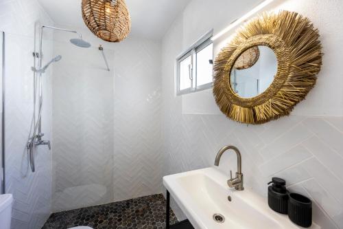 Un baño con lavabo, espejo y ducha. en Casa Ana Mar, en Vila do Bispo