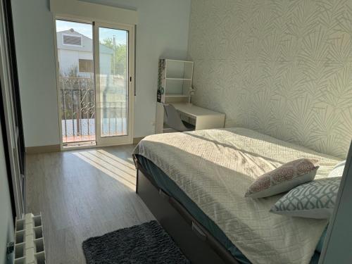 a bedroom with a bed and a large window at Casa Estrella Gandia in Gandía