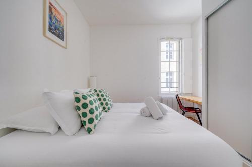 une chambre avec un lit blanc avec des oreillers blancs dans l'établissement L'Eclat Bordelais - Appt au coeur de Bordeaux, à Bordeaux