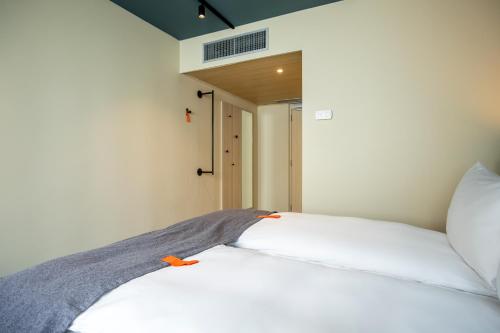 ブリュッセルにあるCitybox Brusselsのベッドルーム1室(オレンジ色のオブジェクトが付いた白いベッド1台付)