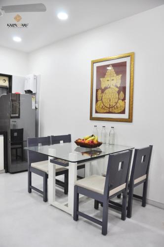 a dining room with a white table and chairs at Kalpattaru Sadan Luxurios 3BHK in Pune