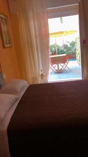 a bedroom with a bed and a window with a patio at Affittacamere Selene in Sanremo