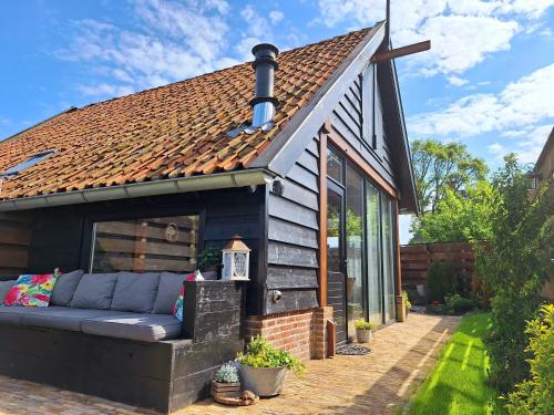 a small house with a couch in the backyard at Bed & brochje By ús thús in Ternaard