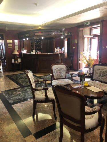 een lobby met stoelen en een tafel en een bar bij Villa Hotel in Debrecen