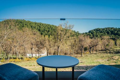 a table in a room with a view of a mountain at Pachán Dehesa Boyal in Cuenca