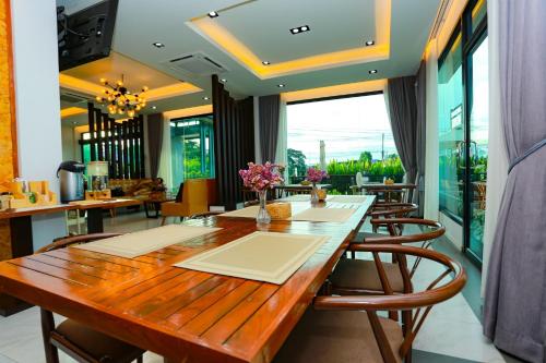a dining room with a wooden table and chairs at My Memory Mueang Loei in Loei
