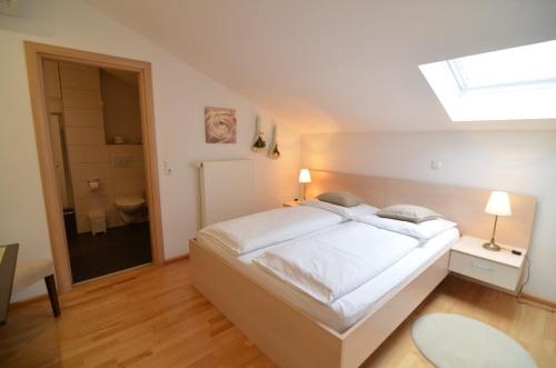a bedroom with a large white bed and a skylight at Villa Diana Zadar in Zadar