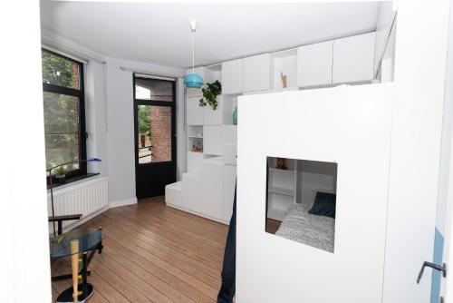 a living room with white cabinets and a bed at Townhouse Tongeren Center - Featured in Designbook in Tongeren