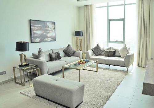 a living room with two couches and a table at Farhan Tower in Juffair
