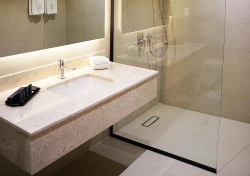 a bathroom with a sink and a shower at Farhan Tower in Juffair