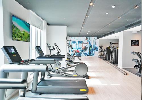 a gym with several treadmills and cardio machines at Farhan Tower in Juffair