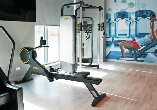a gym with a woman exercising on a treadmill at Farhan Tower in Juffair