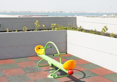 a green and yellow chair sitting on top of a roof at Farhan Tower in Juffair
