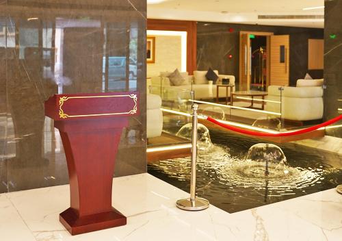 a lobby with a fountain with a boat in a room at Farhan Tower in Juffair