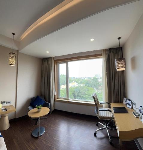 an office with a desk and a large window at The Fern Residency Sarnath in Varanasi