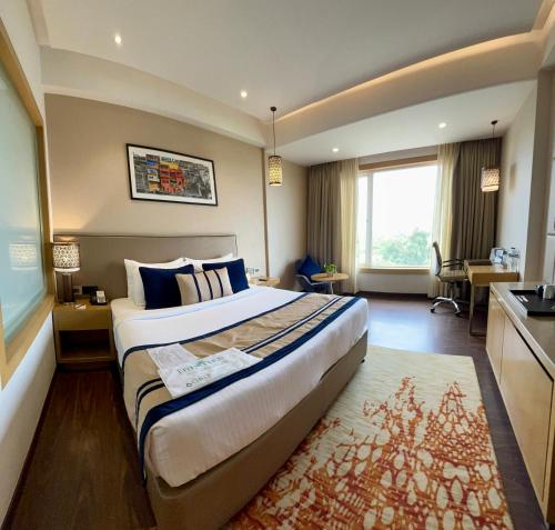 a hotel room with a large bed and a kitchen at The Fern Residency Sarnath in Varanasi
