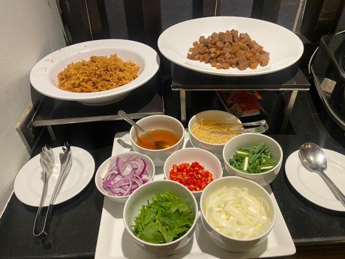 a bunch of bowls of food on a table at Sunee Grand Hotel and Convention Center in Ubon Ratchathani