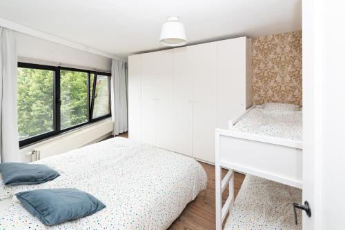 a bedroom with a bed and a window at Townhouse Tongeren Center - Featured in Designbook in Tongeren