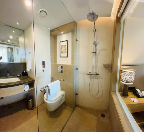 Un baño con inodoro, lavabo y ducha. en The Fern Residency Sarnath, en Varanasi
