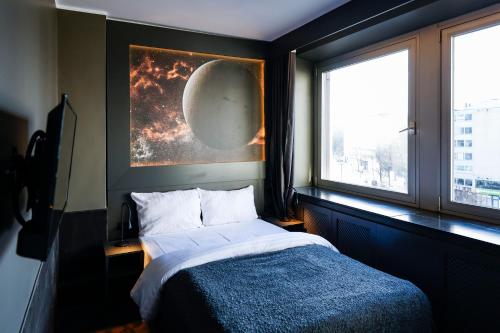 a bedroom with a bed and a picture of the moon at Sleephotels Cosmos in Hamburg