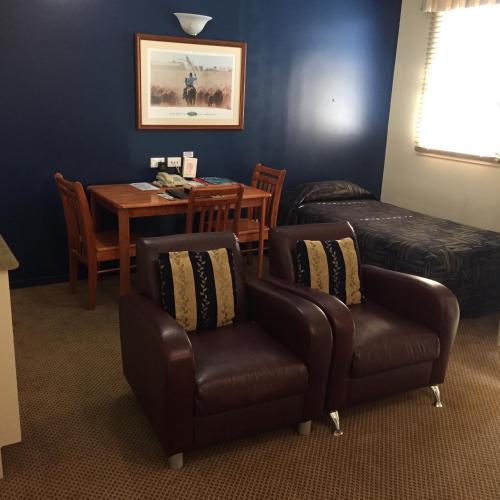 a room with a table and chairs and a table and a table and chairs at Criterion Hotel-Motel Rockhampton in Rockhampton
